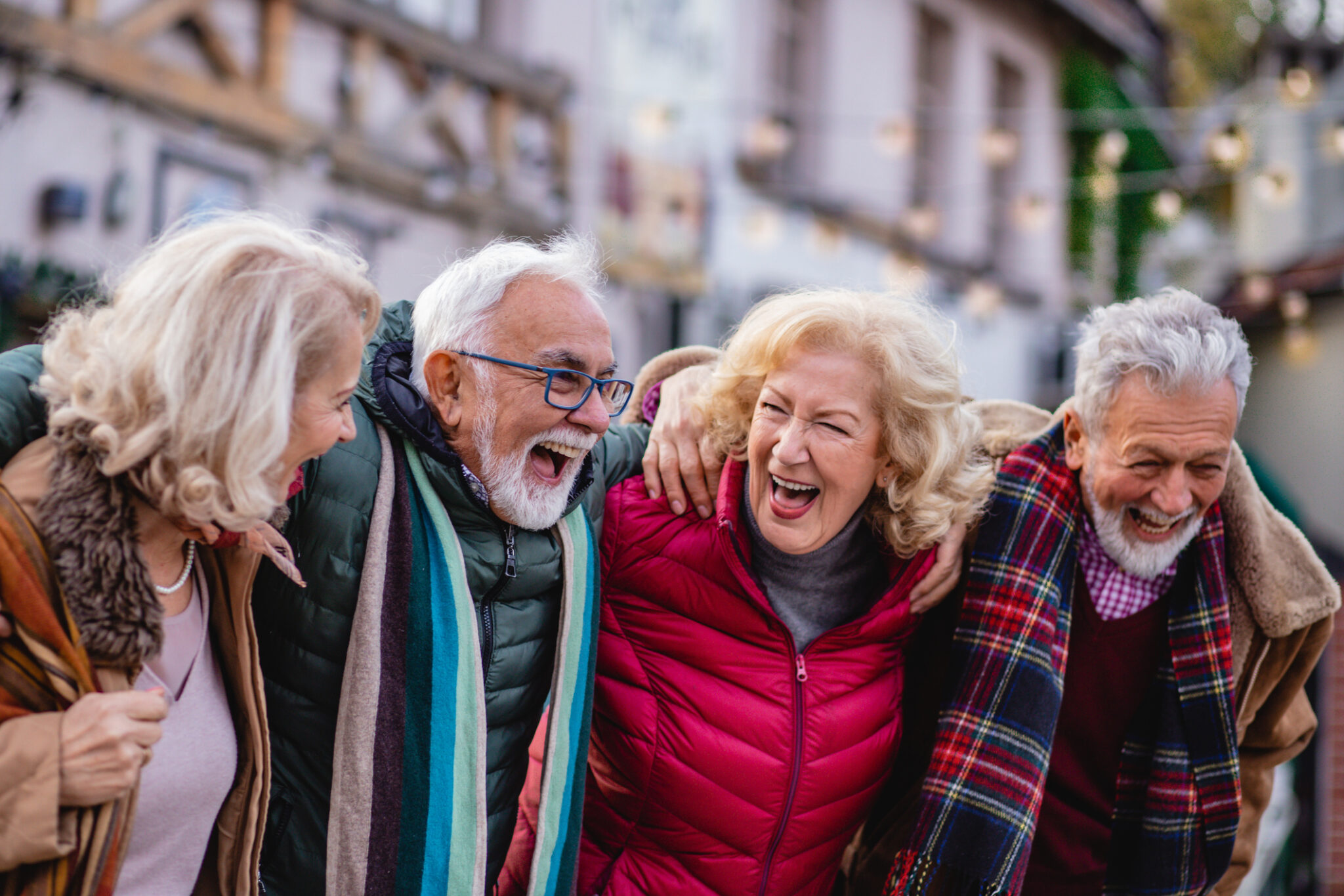 A group of seniors taking, walking and laughing outdoors